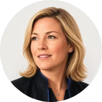 Portrait of a woman with shoulder-length blonde hair wearing a dark blazer against a light background.