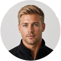 Portrait of a man with blond hair wearing a dark collared shirt against a light background.